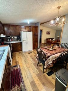 una cucina con un tavolo e un frigorifero bianco di Black Bear Hideaway a Pickens