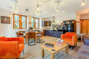 a kitchen and living room with orange chairs and a table at Gardeners Cottage at Craighead in Huntly