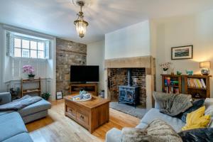 a living room with a fireplace and a tv at Eastgate House Alnwick in Alnwick