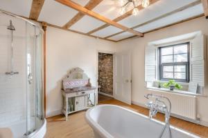 a bathroom with a bath tub and a window at Eastgate House Alnwick in Alnwick +28 photos