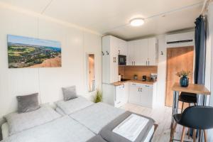 a small bedroom with a bed and a kitchen at Hernádrental Apartmanok in Felsődobsza