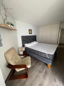 un dormitorio con una cama y una silla en San Alfonso Del Mar, Algarrobo, en Algarrobo