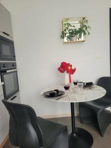 un tavolo bianco con sedie e un vaso di fiori di Loveroom Instants Secret Amiens ad Amiens Altre 20 foto