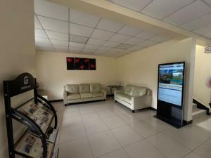 a waiting room with couches and a large screen at Kigali Phoenix Serviced Apartments in Kigali +7 photos