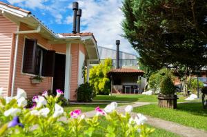 a house with flowers in the yard at Pousada Gramadense in Gramado