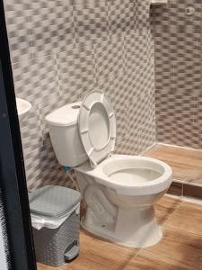 a bathroom with a toilet with the lid up at SAN ALEJO- CABAÑAS Y CAMPING in Tota