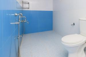 a bathroom with a toilet and a blue wall at Kalash Apartments with Kitchen in Calangute