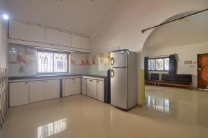 a kitchen with a refrigerator in the middle of a room at Kalash Apartments with Kitchen in Calangute