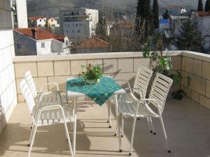 a table and chairs on a balcony with a view at Apartments and Rooms Artemida in Dubrovnik