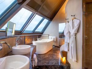 a bathroom with two sinks and a large window at MÖVENPICK Hotel Hamburg City in Hamburg