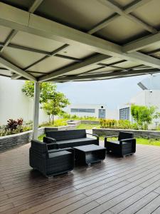 a patio with couches and a table and chairs at Maple Grove Yasuragi Stay in General Trias