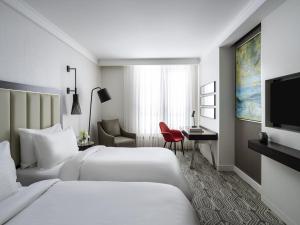 una camera d'albergo con due letti e una televisione di Mövenpick Istanbul Hotel Golden Horn a Istanbul
