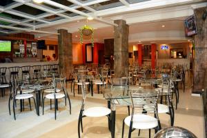 a restaurant with tables and chairs and a bar at La Posh Hotel in Kigali