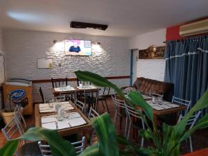 a restaurant with wooden tables and chairs and a couch at Hotel Cesar in San Luis