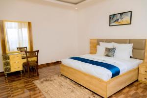 een slaapkamer met een bed, een tafel en een stoel bij Million Views Kigali in Kigali +10 foto's