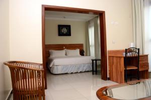 a bedroom with a bed and a desk and a mirror at La Posh Hotel in Kigali +21 photos