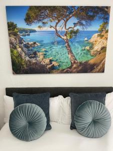 a painting hanging above a bed with two pillows at Hossi-Rathaus in Kempten