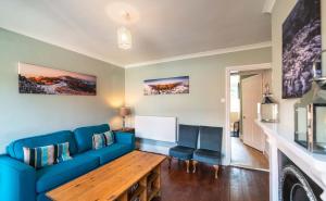 ein Wohnzimmer mit einem blauen Sofa und einem Tisch in der Unterkunft Cosy Character Home - 2 Beds in Malvern in Great Malvern