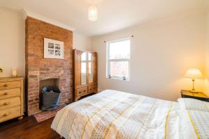ein Schlafzimmer mit einem Bett und einem gemauerten Kamin in der Unterkunft Cosy Character Home - 2 Beds in Malvern in Great Malvern