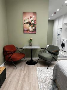 una stanza con due sedie e un tavolo e un quadro di Апарт-отель Urban Luxe Nest one B Sky-High Luxury a Tashkent Altre 16 foto