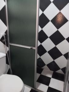 a bathroom with a shower with a toilet and a checkered floor at Pousada COP 30 E Cirio 2025 in Belém