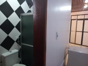 a bathroom with a toilet and a green door at Pousada COP 30 E Cirio 2025 in Belém