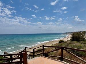 een uitzicht op een strand met mensen die op het zand lopen bij Private Solarium - Golf and Pool View - Las Ramblas 830 in Orihuela-Costa