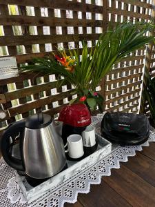 a tray with a tea kettle and cups on a table at Recanto do Sol in Paranaguá