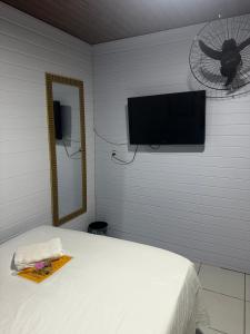 a bedroom with a bed and a tv and a fan at Recanto do Sol in Paranaguá