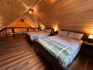 a bedroom with two beds in a wooden cabin at Amphitheater Mountain Cabin in Silver Gate