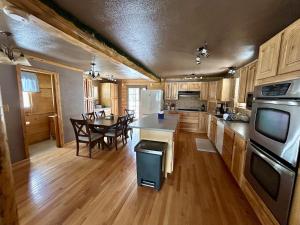 a large kitchen with a table and a dining room at Amphitheater Mountain Cabin in Silver Gate