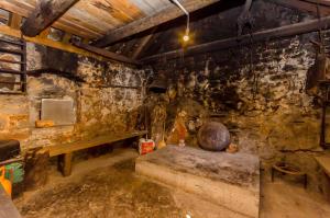 a room with a stone wall with a bench in it at House Mateljan in Poljica