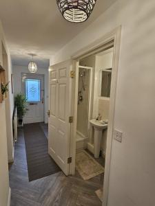 a hallway with a bathroom with a sink and a mirror at Stunning Contractor home, Company workers WLC, Netflix in Sandal and Walton