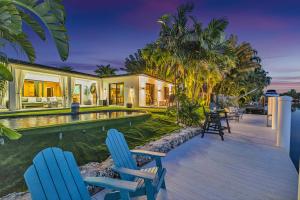 フォート・ローダーデールにあるWaterfront Heated Pool Martini Key Residenceの青い椅子2脚とスイミングプールが備わる家