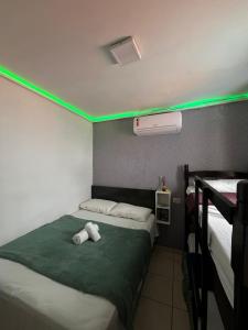 ein Zimmer mit zwei Betten, die mit grünen Lichtern beleuchtet sind in der Unterkunft casa 3 quartos1suíte com frigobar smart tv netflix ar-condicionado in Campina Grande