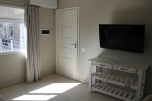 a living room with a flat screen tv and a door at Departamentos Apart PM in Necochea