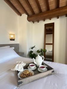 a tray with three bowls and a vase on a bed at Under The Tuscan Sun in Arezzo