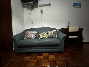 a blue couch in a living room with pillows on it at Campinho Café Alojamento Local in Fátima