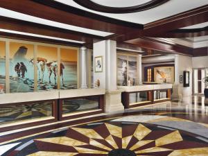 ドバイにあるMövenpick Hotel & Apartments Bur Dubaiの壁に大きな絵が飾られたロビー