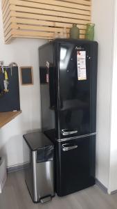 frigorifero nero in cucina con tavolo di Appartement entre le port et le vieux quartier a La Roche-Bernard