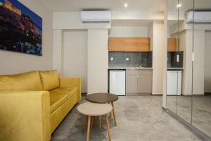 a living room with a yellow couch and a table at Aristotelous Downtown Suites in Thessaloniki