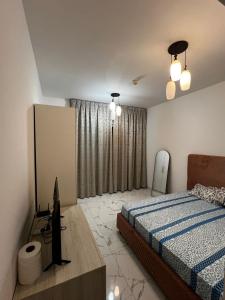 a bedroom with a bed and a television in it at Sea View Rooms in Ajman in Ajman 