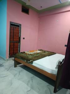 una camera con un letto su una parete rosa di Chandrika Palace Agnikund Near RAM MANDIR a Ayodhya Altre 2 foto