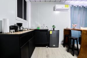 a kitchen with black cabinets and a counter top at Módulos Yunni in Uvita
