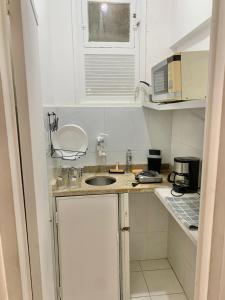 een kleine keuken met een spoelbak en een magnetron bij Centro - Ao lado da Lapa in Rio de Janeiro