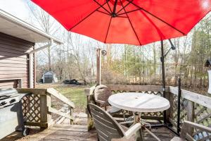 a red umbrella on a deck with a table and chairs at Bungalow in a Quiet Neighborhood in Waterloo +78 photos