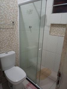 une salle de bain avec toilettes et douche en verre dans l'établissement Refúgio em Boipeba - Casa de Praia com Varanda e Conforto Tropical, à Cairu 6 autres photos
