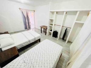 une chambre avec deux lits, une table et des étagères dans l'établissement Casa Playa Blanca, a private beach home, à Ixtapa-Zihuatanejo International 36 autres photos
