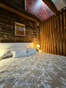 a bed in a room with a wooden wall at Casa Folibar in Manzanedo de Valdueza