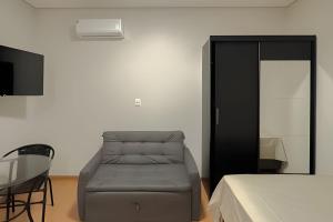 um quarto com uma cama, uma cadeira e uma mesa em Flats_Sabia em Uberlândia